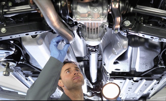 Technician checking exhaust - Exhaust repairs woking